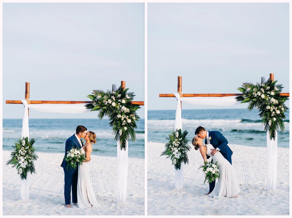 couple kissing under wedding arch on the beach
