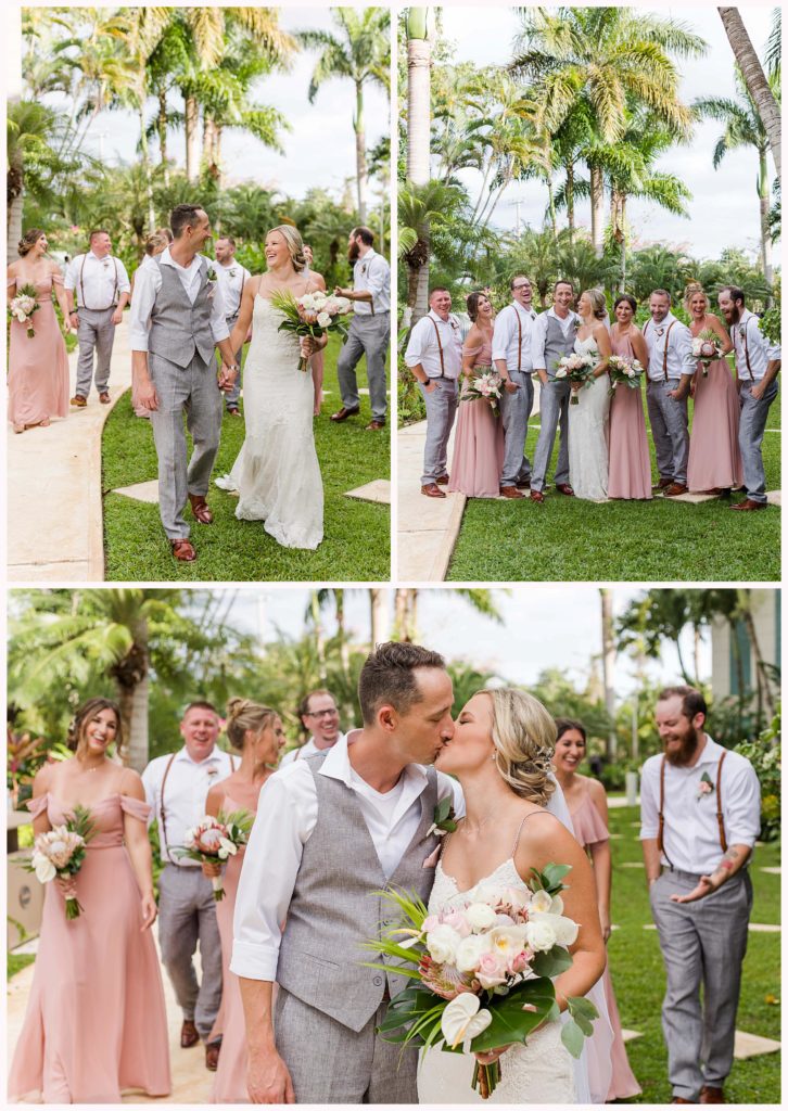bride and groom share a kiss in front of their bridal party with tropical details