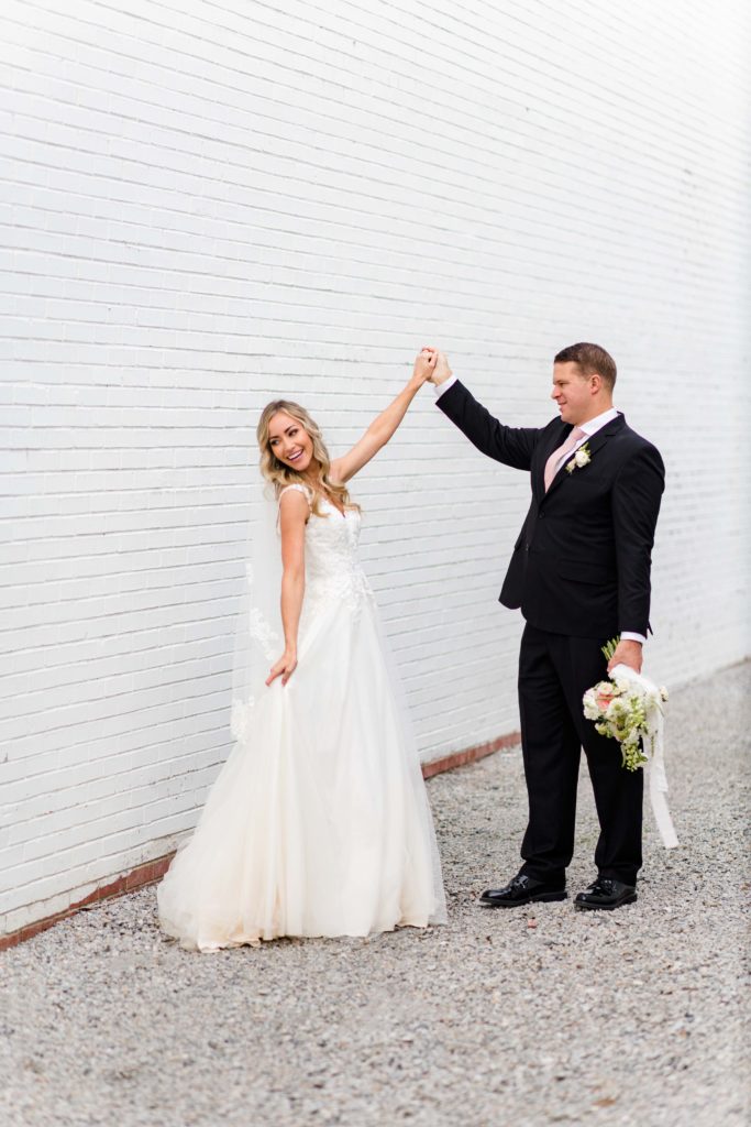 light and airy photo of bride and groom against white wall