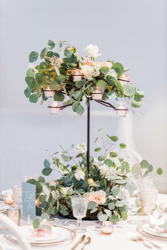 double layer floral arrangement on white table with fresh eucalyptus 