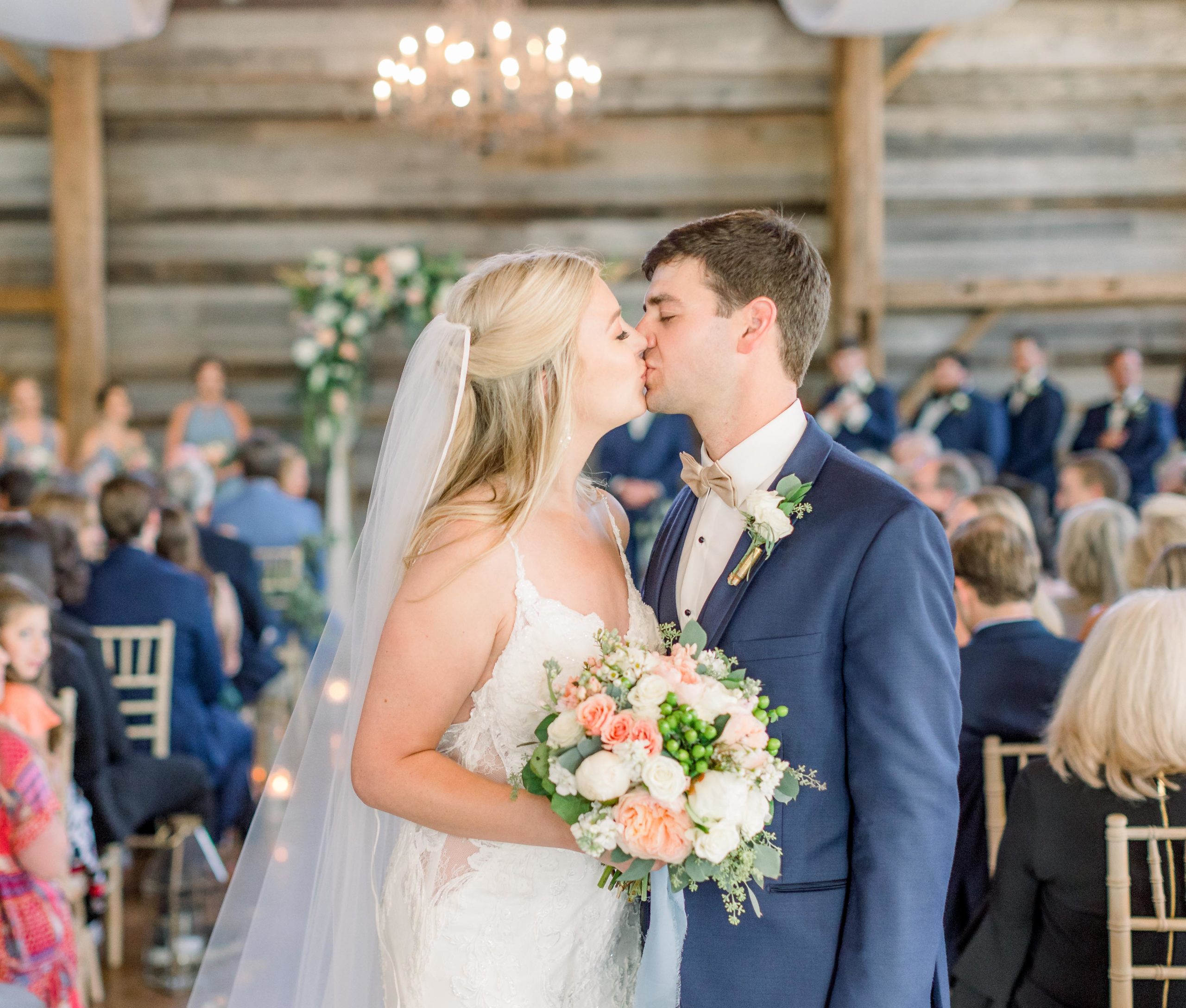 bride and groom share kiss at the end of the aisle at madison, mississippi wedding