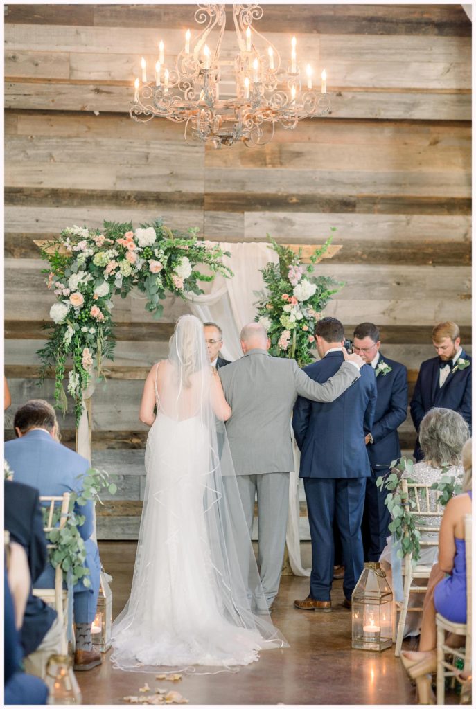 bride's father puts arm around groom at wedding