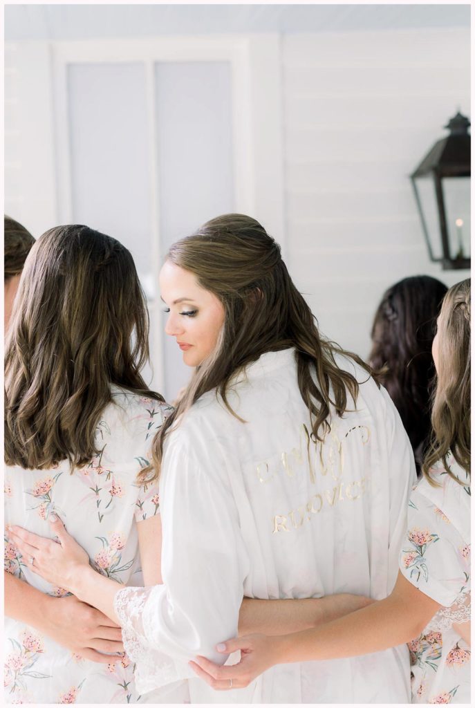 bride poses with robe that has last name