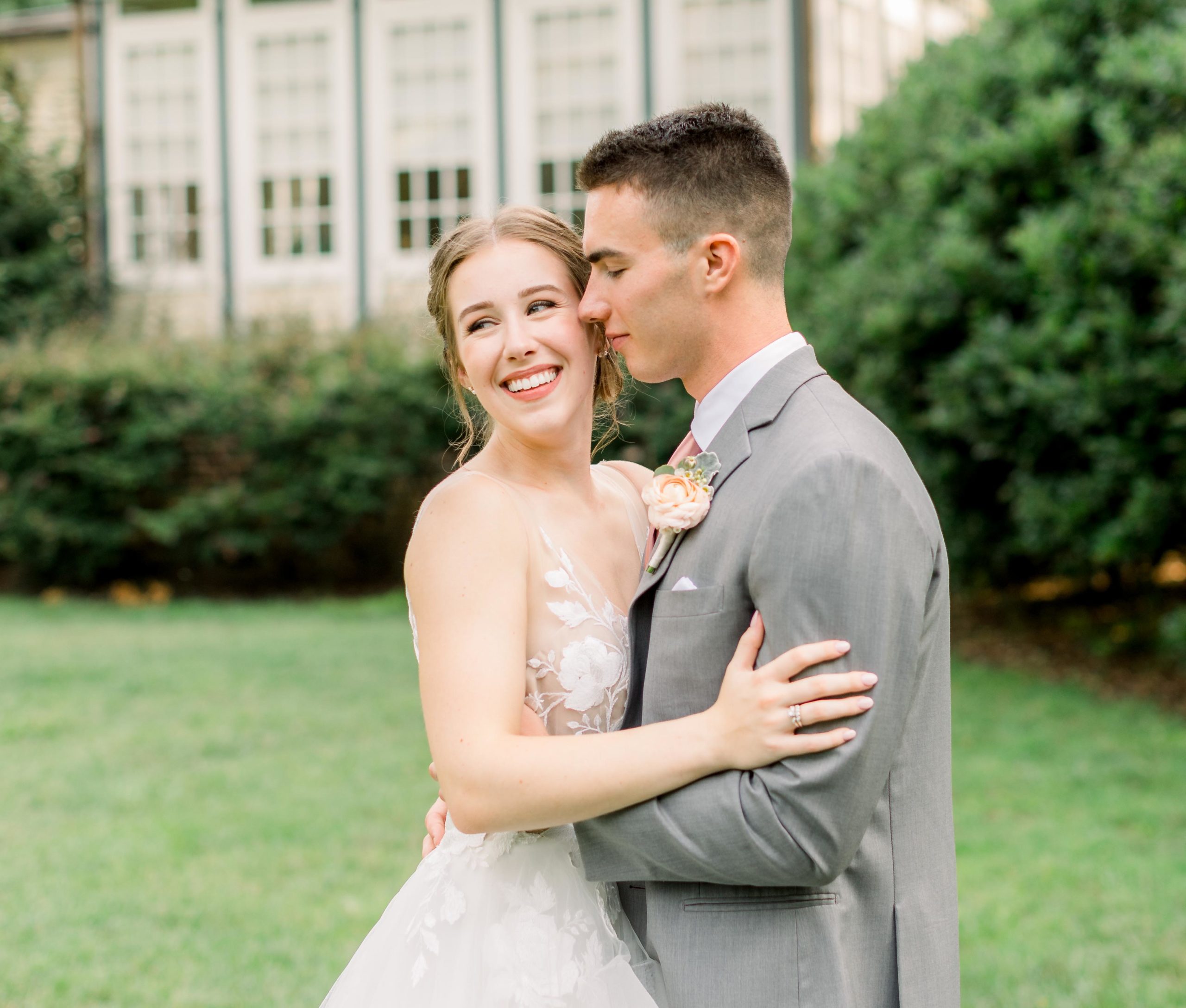 couple embraces on wedding day in front of the alexander homestead