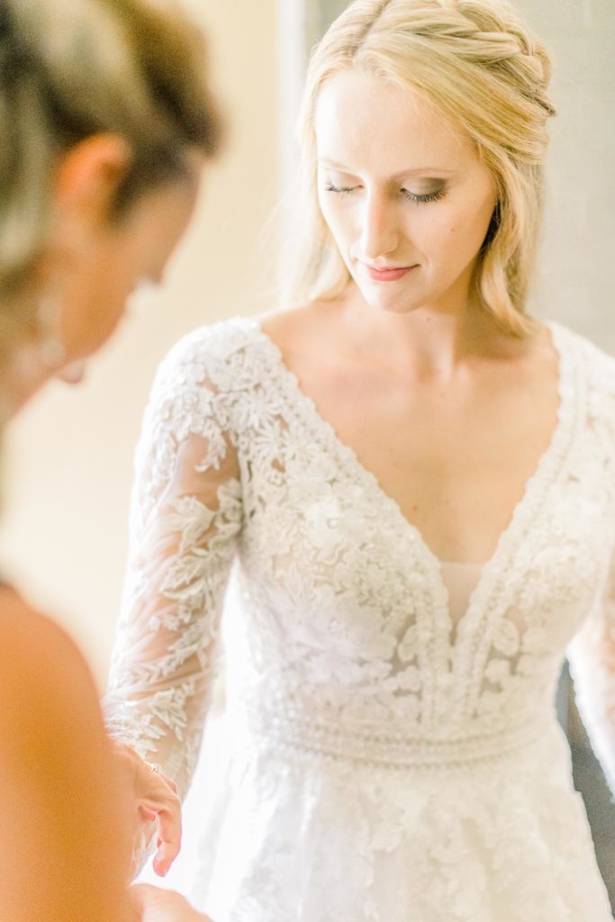bride's mom fixes long sleeve on classic wedding dress