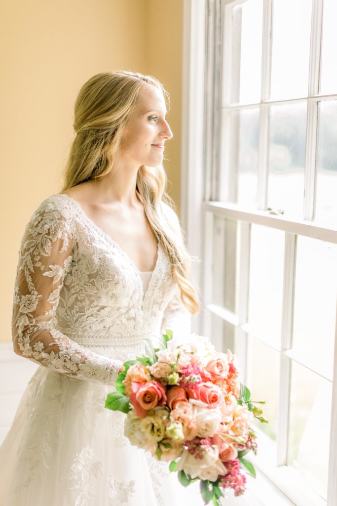 bride gazes out window at the bridal suite at oakland farm in north carolina