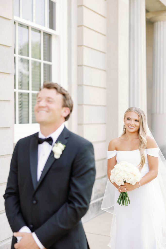 bride and groom share first look on the steps of the old capitol in jackson, mississippi