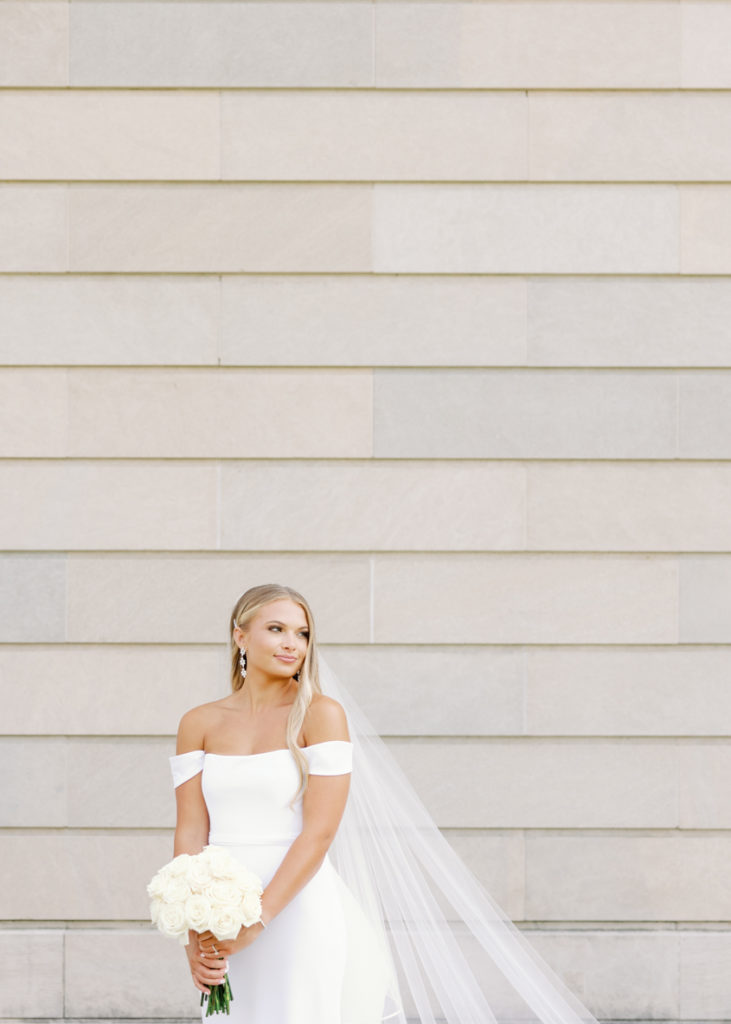 classic bride poses against a monument on mississippi wedding day