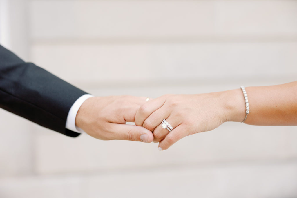 hands with rings share a touch before wedding day