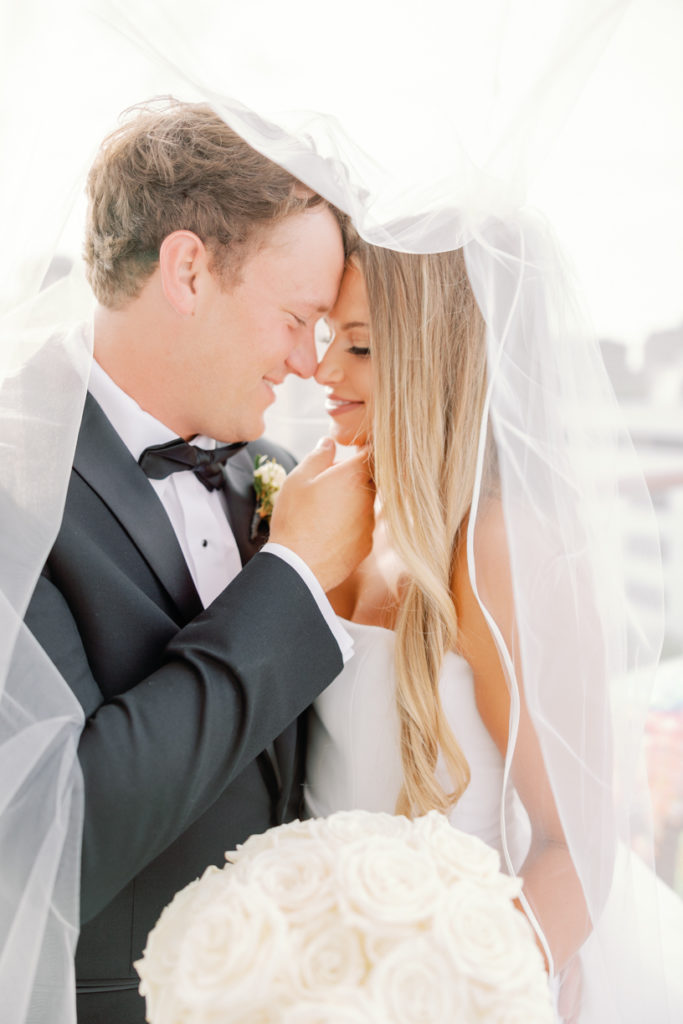 bride and groom share a kiss under their veil
