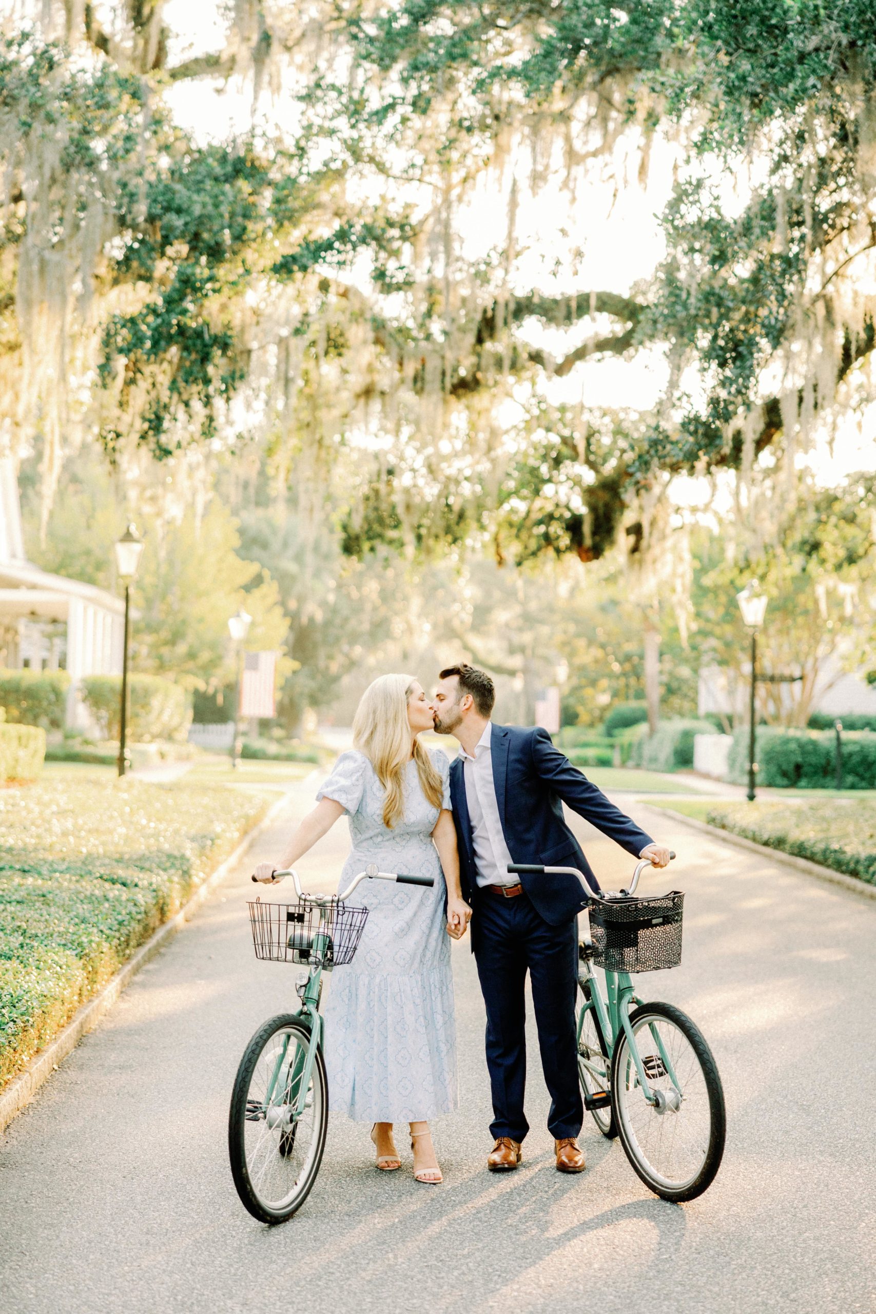 bride and groom to be ride bikes through palmetto bluff during engagement session