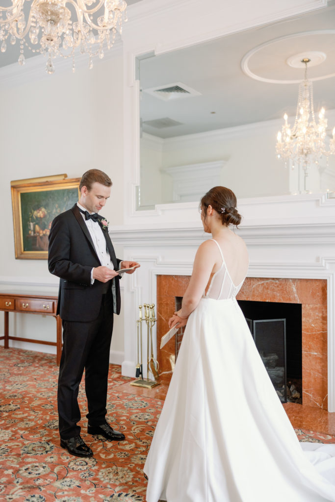 bride and groom stand in front of white fireplace at providence country club