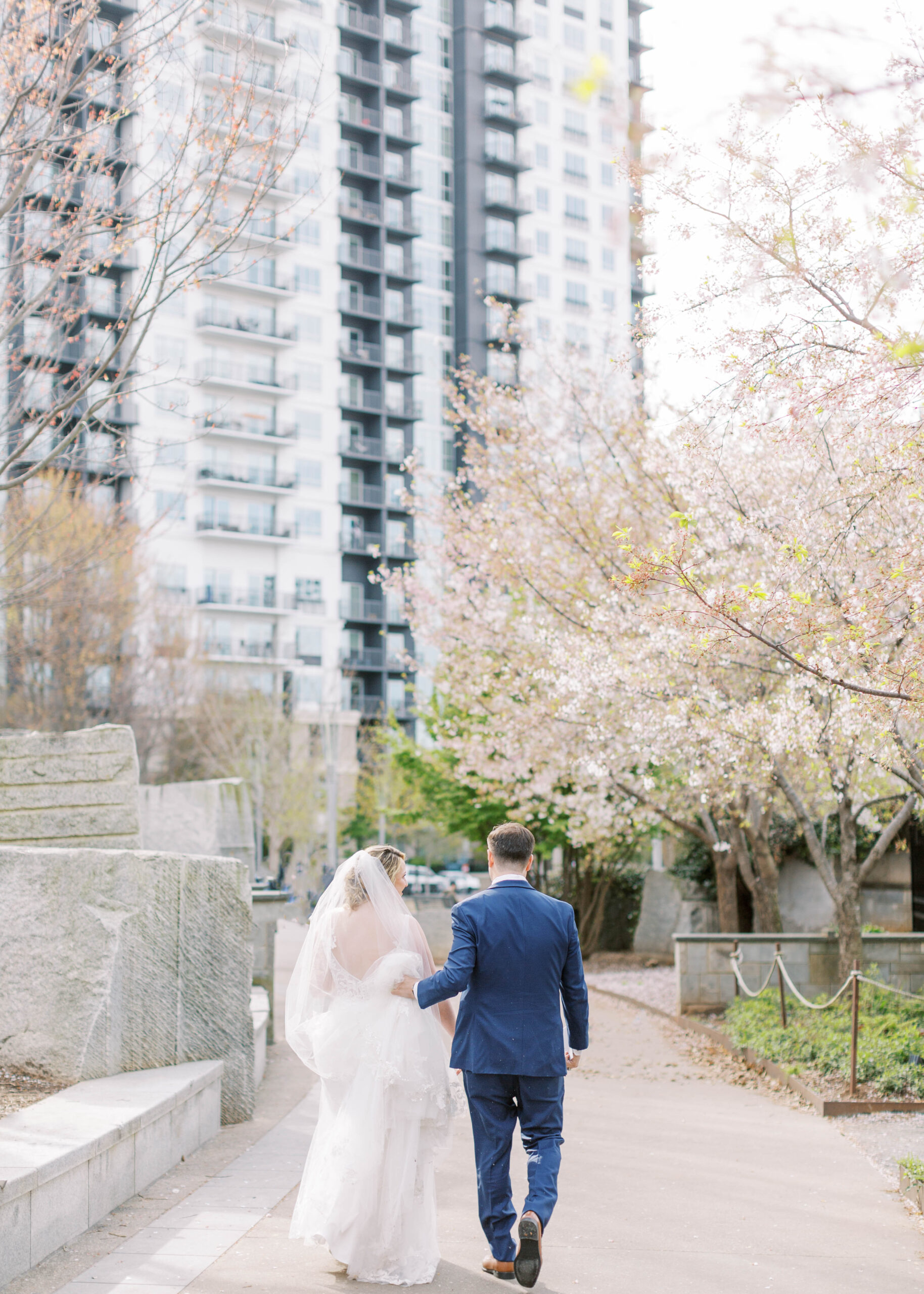 bride and groom walk during the spring in uptown charlotte