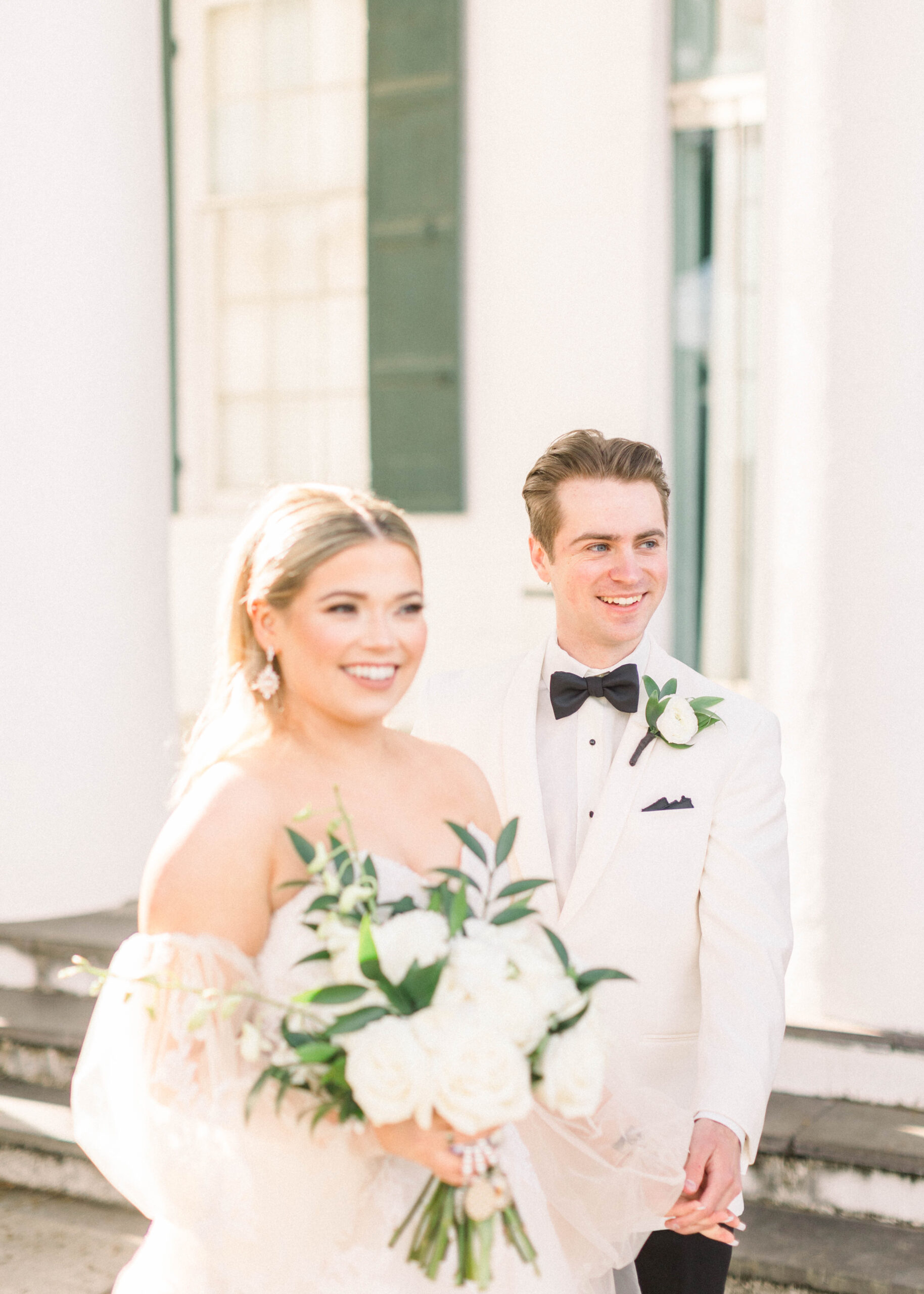 bride and groom in white in candid wedding day photo at their southern wedding day
